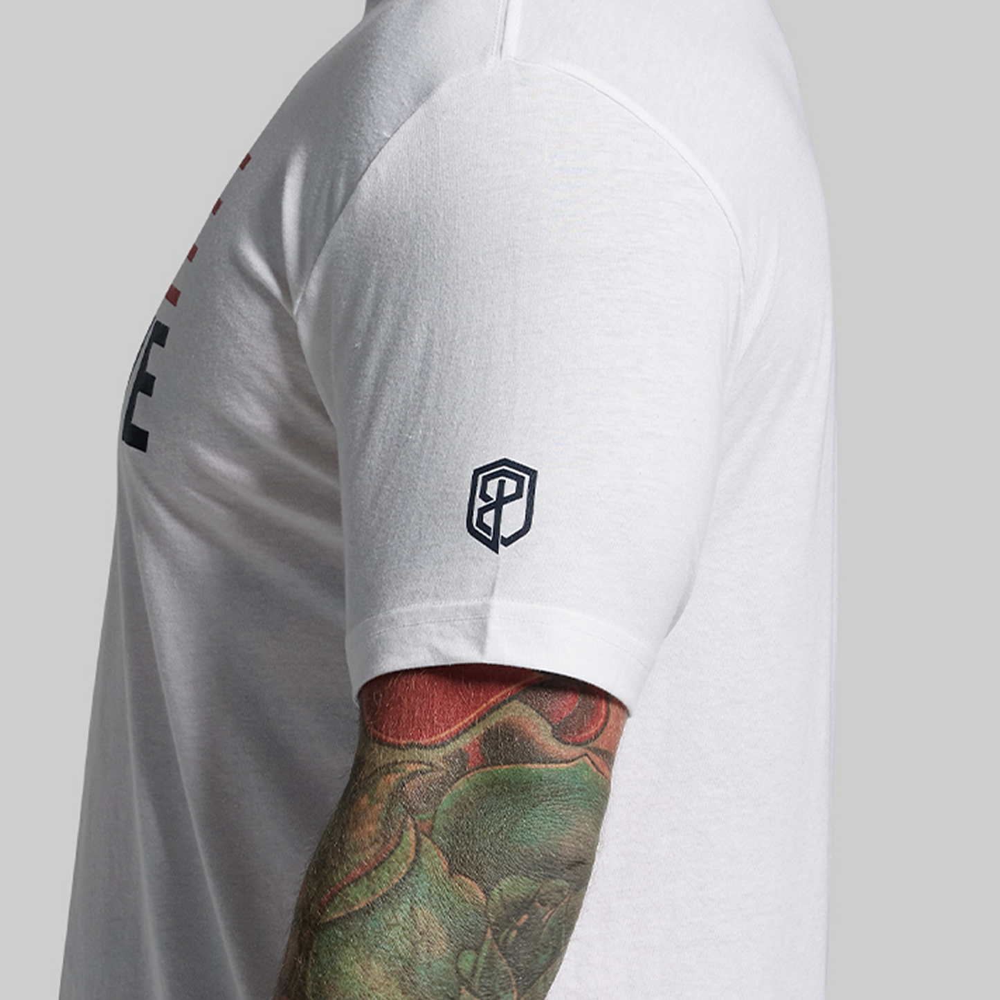 Person wearing a white athletic shirt with a logo on a plain background