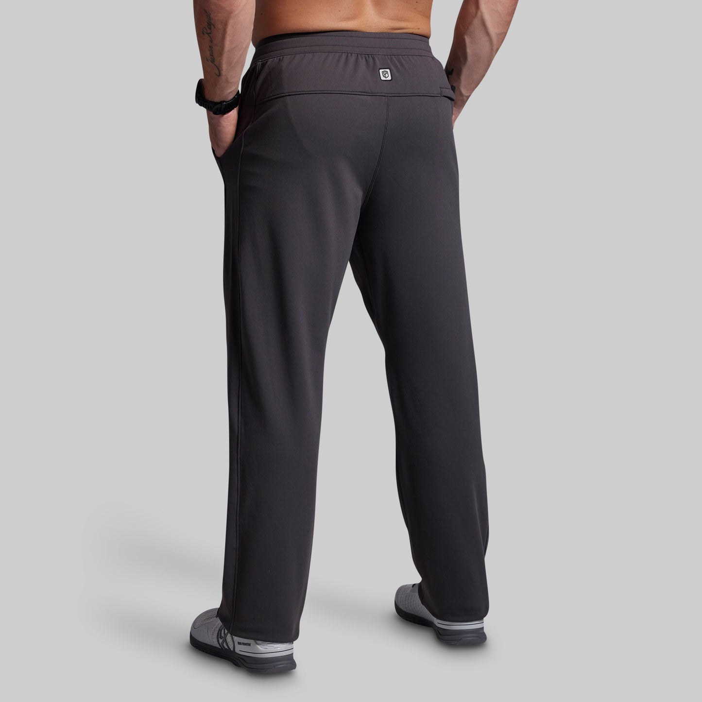 Person wearing dark gray athletic pants on a light gray background