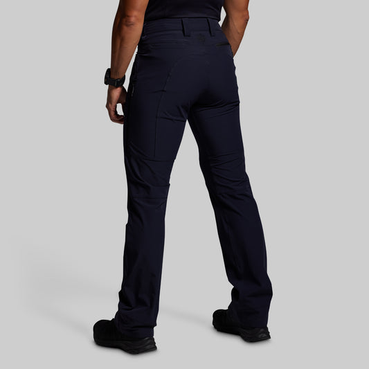 Person wearing dark blue outdoor pants on a gray background