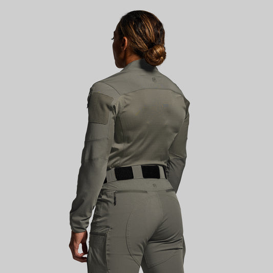 Person wearing a green tactical outfit on a gray background