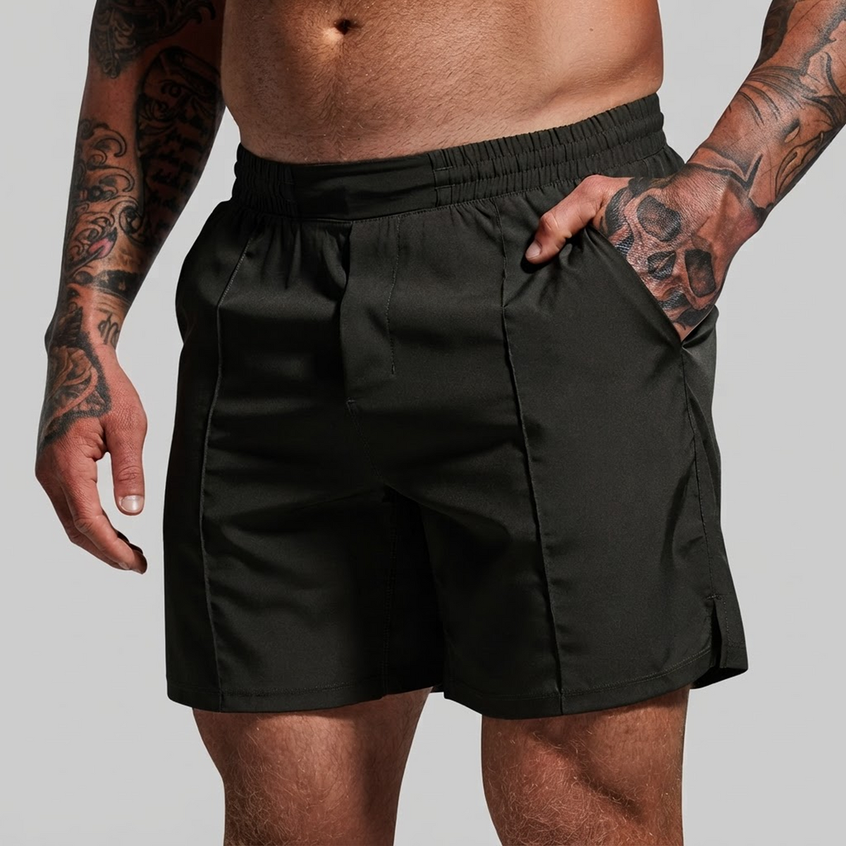 Green athletic shorts worn by a tattooed male model, shown from the waist to mid-thigh against a plain light gray studio background.