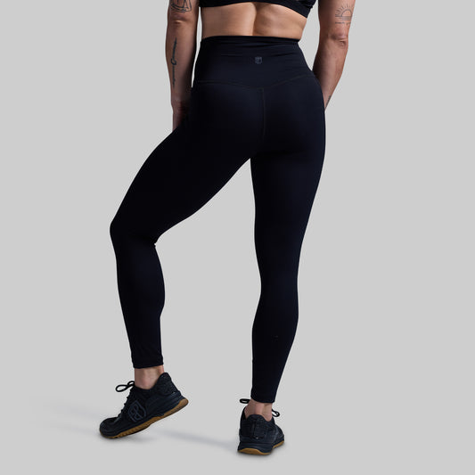 Person wearing black leggings on a gray background