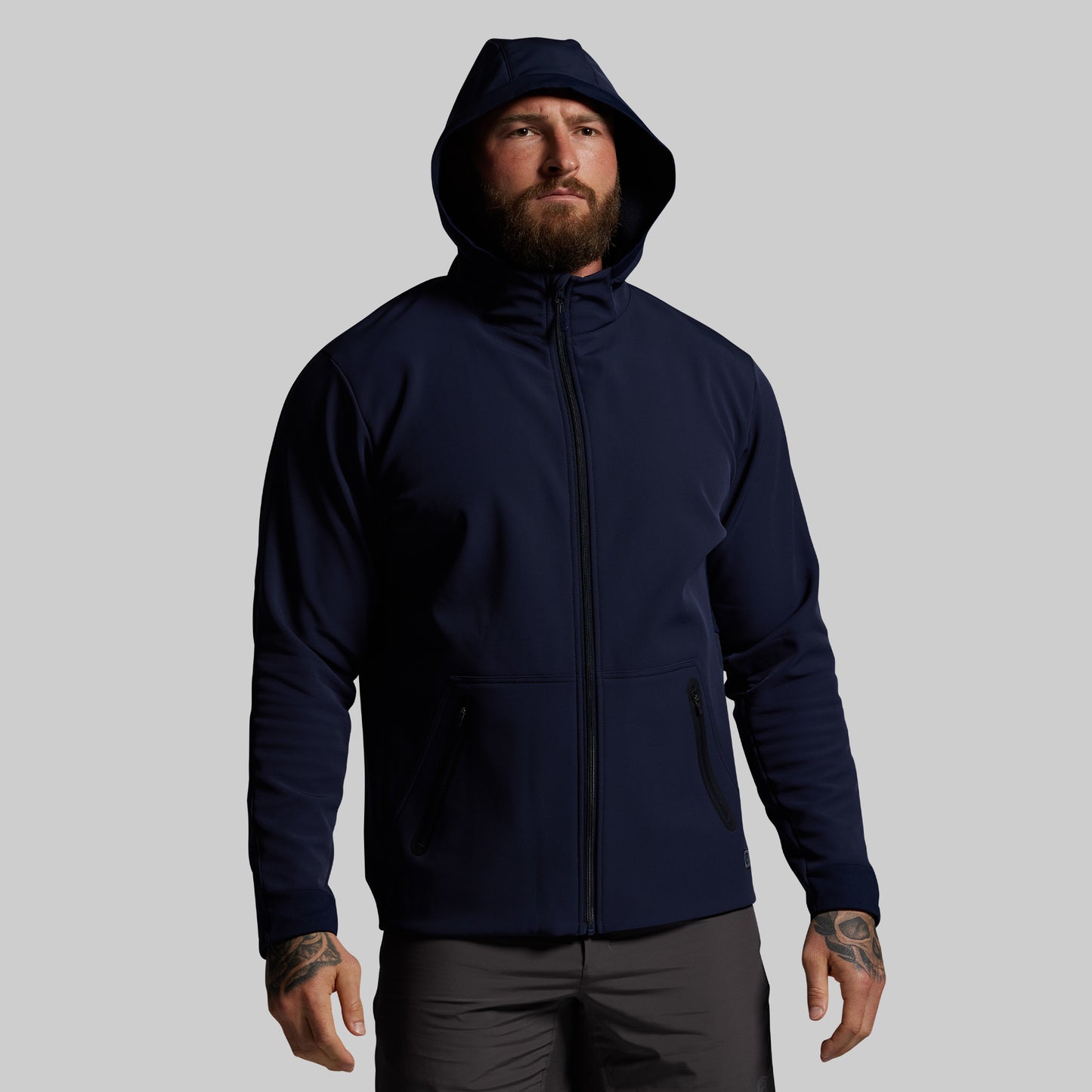 Man wearing a navy blue hoodie on a gray background