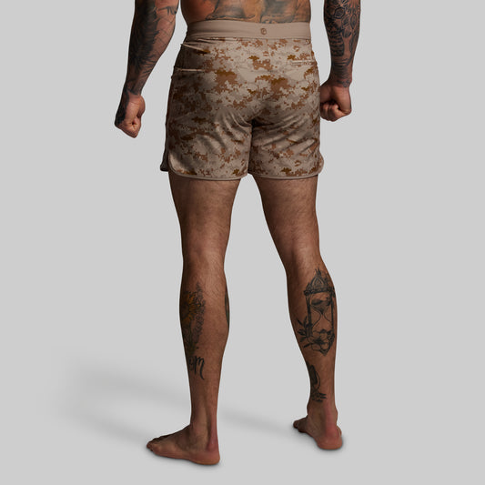 Person wearing camouflage shorts on a plain background