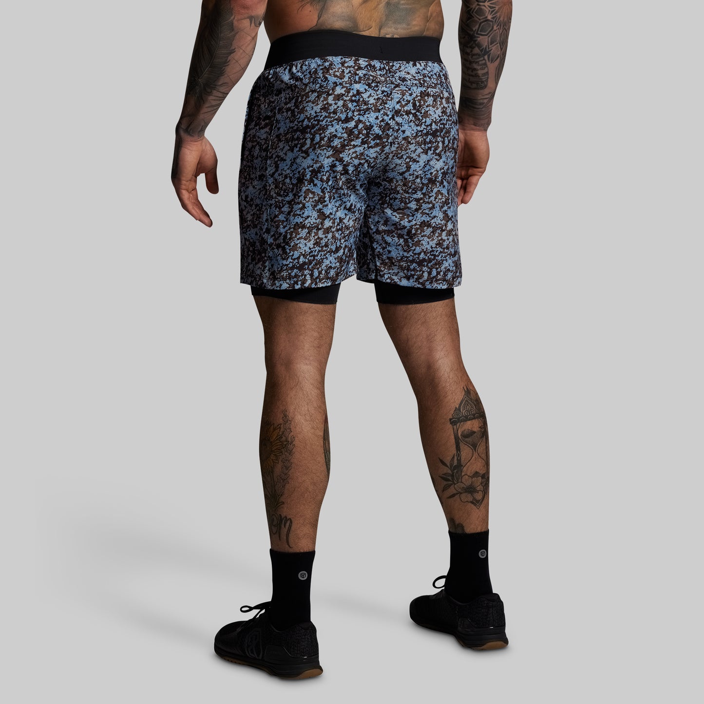 Person wearing camouflage shorts on a gray background