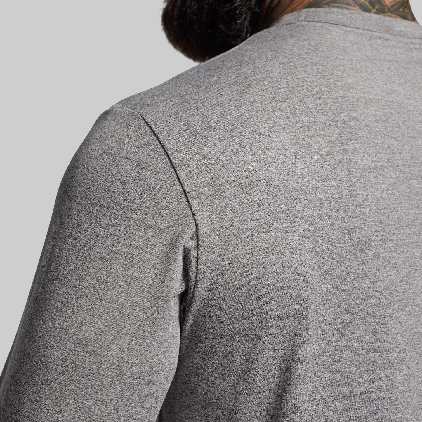 Gray long-sleeve shirt worn by a person on a light gray background