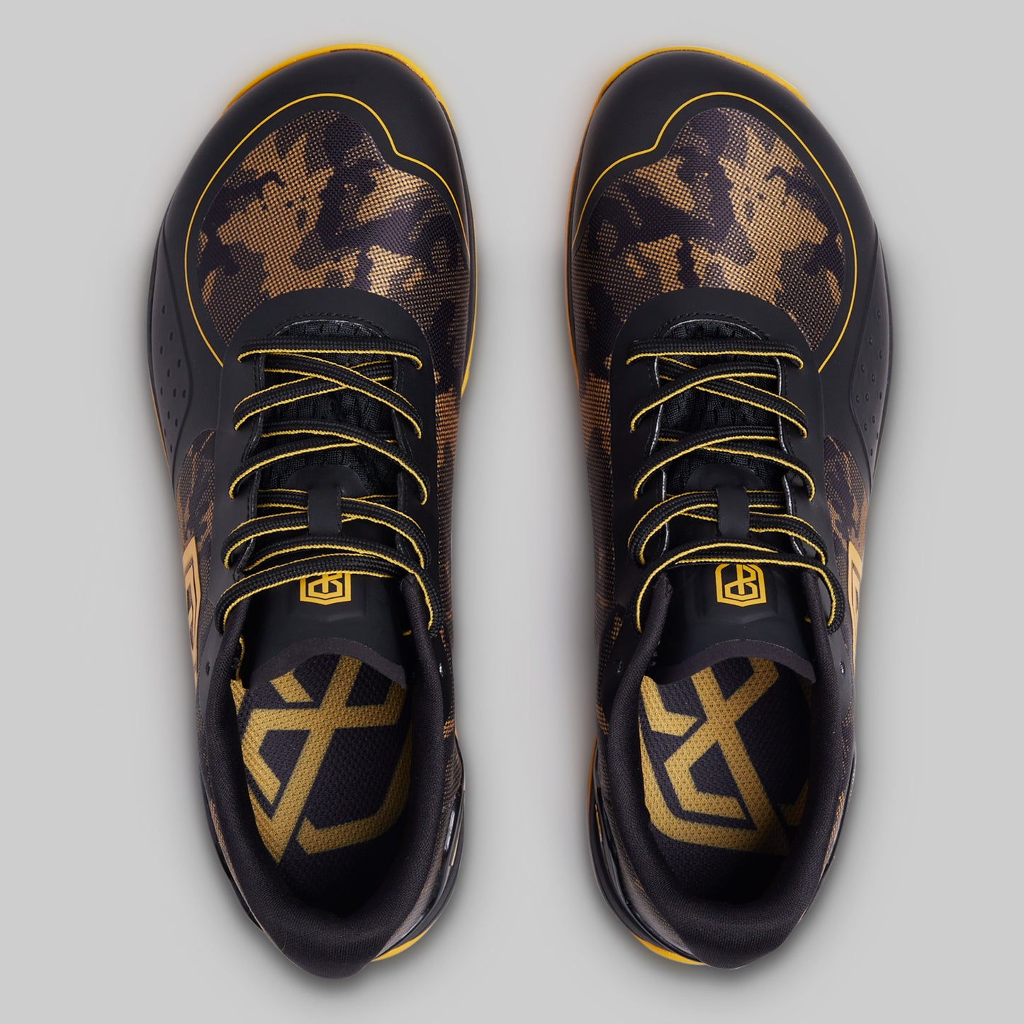 Black and gold sneakers with unique patterns on a light gray background