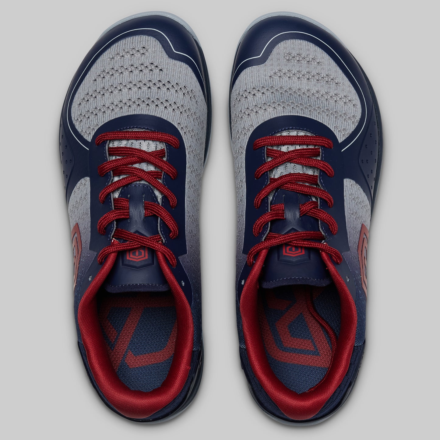 Pair of blue and red athletic shoes on a light gray background