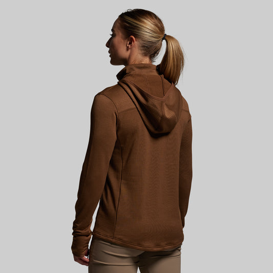 Woman wearing a brown hoodie against a plain background