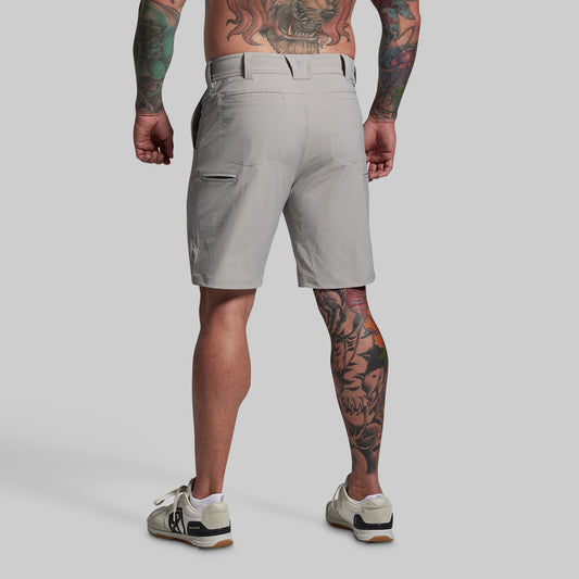 Person wearing gray shorts on a plain background