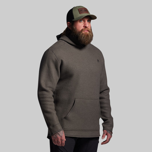 Man wearing a gray hoodie and cap on a gray background
