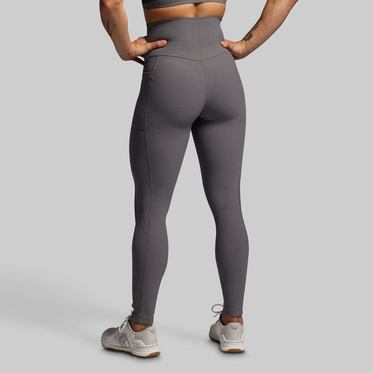Person wearing gray leggings on a plain background