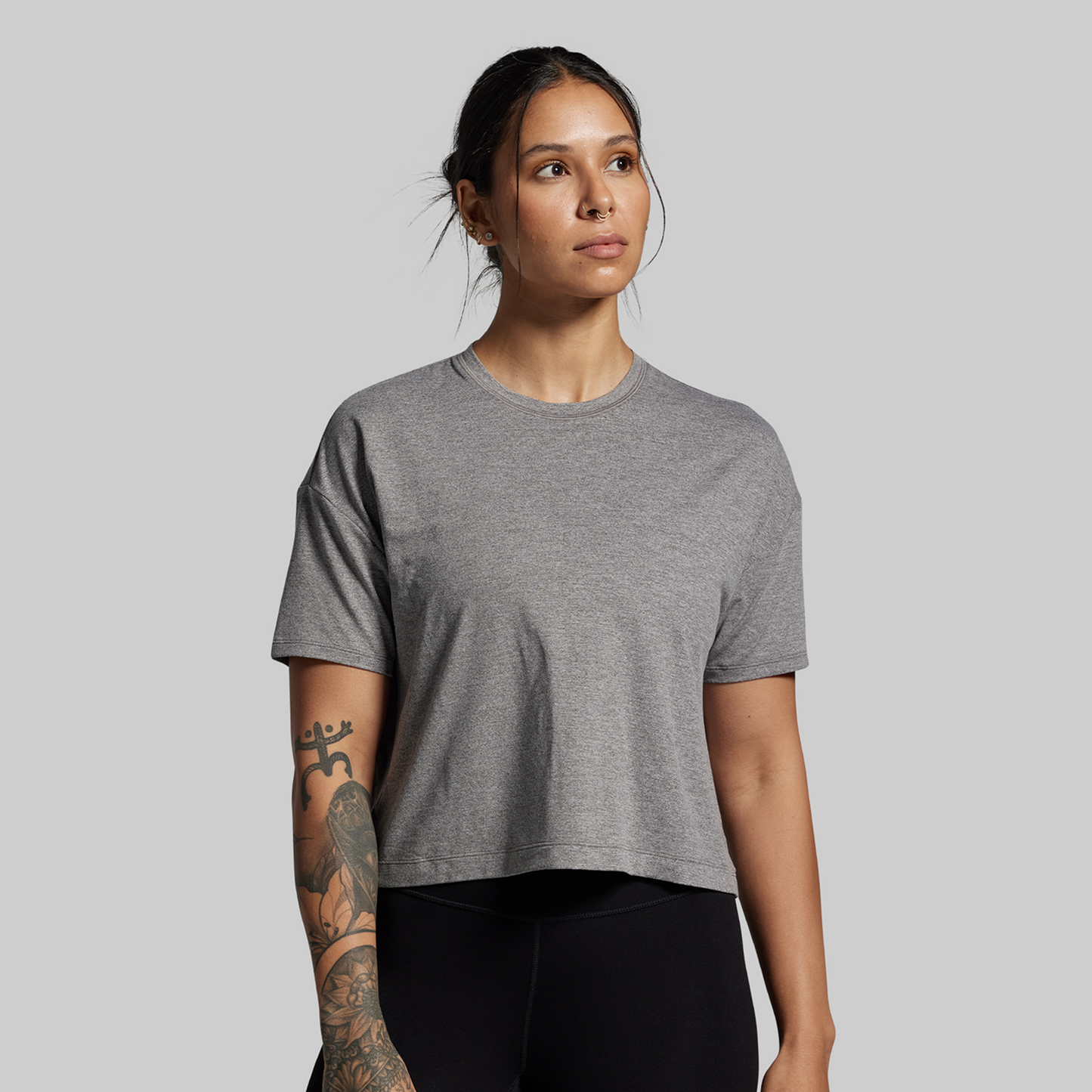 Woman wearing a gray t-shirt against a plain background