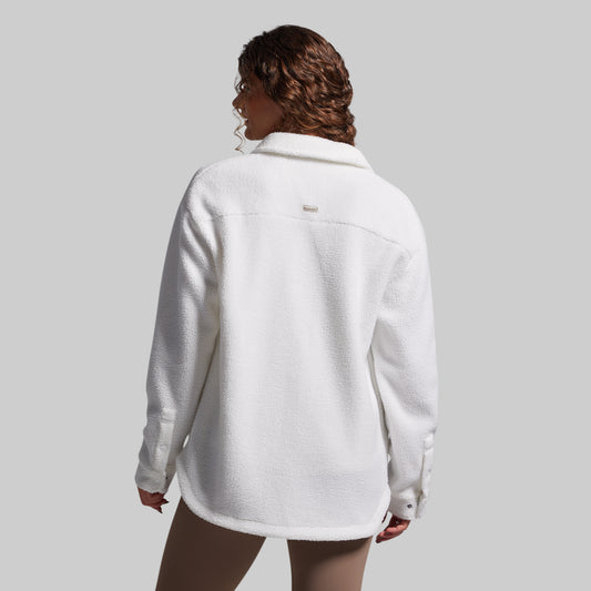 Person wearing a white fleece jacket on a plain background