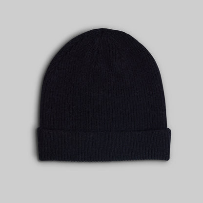 A dark navy blue ribbed knit beanie hat with a folded cuff, shown against a solid light gray background.
