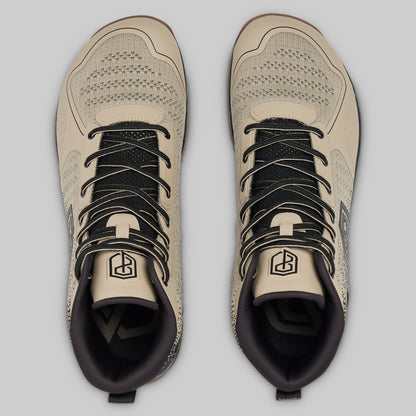 Pair of beige and black sneakers on a light gray background
