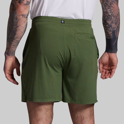 Person wearing green shorts on a plain background