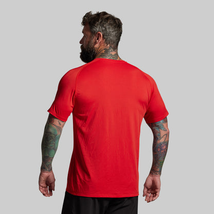Man wearing a red t-shirt on a gray background