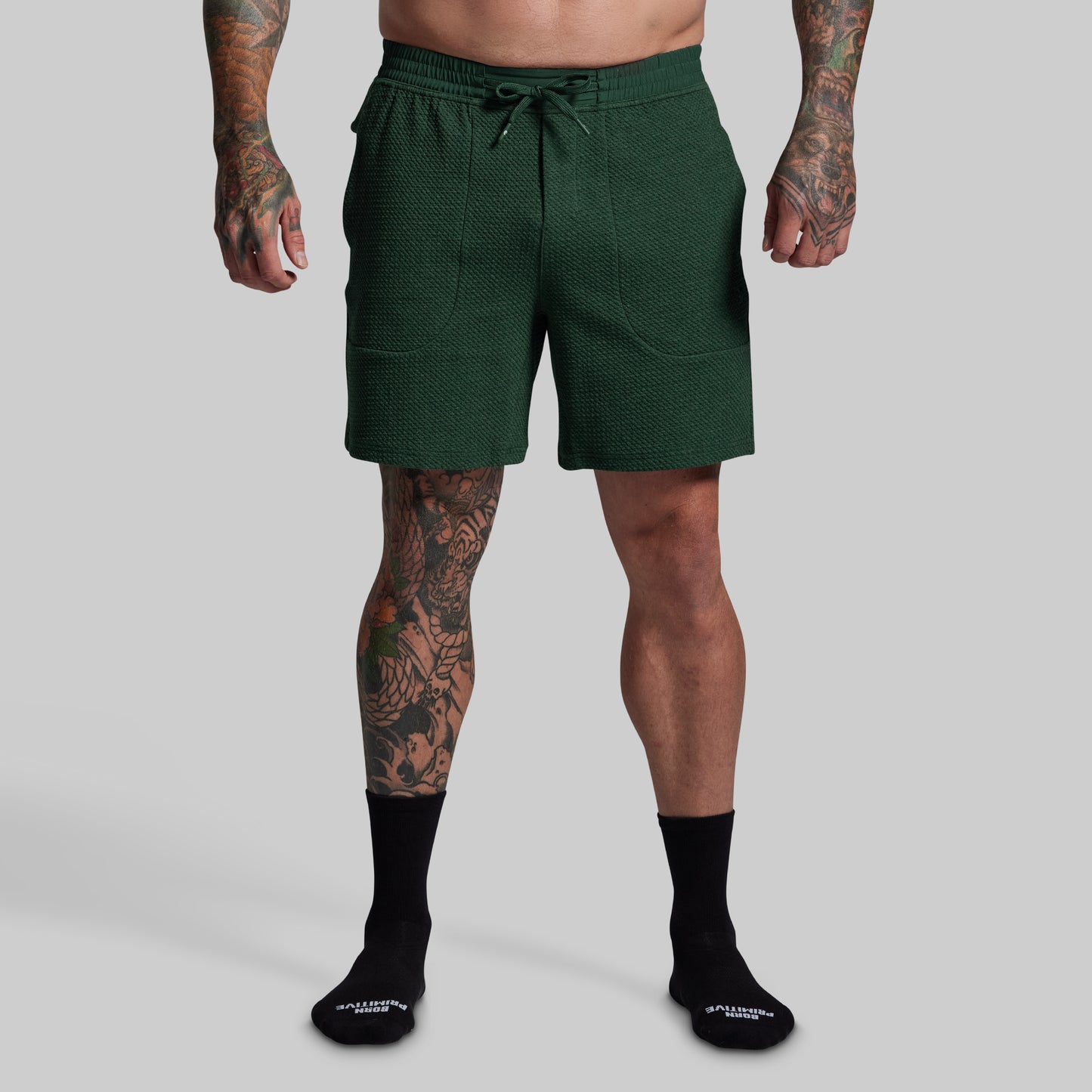 Person wearing green shorts on a gray background