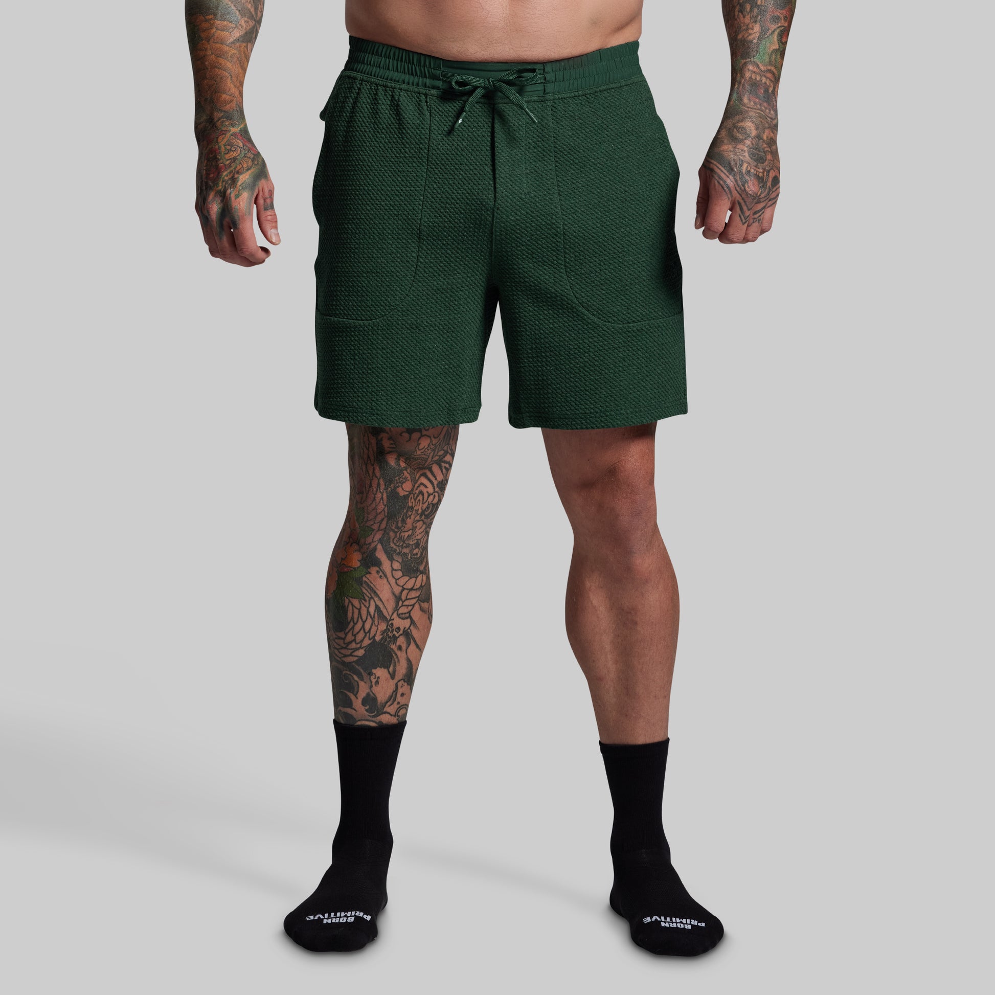Person wearing green shorts on a gray background