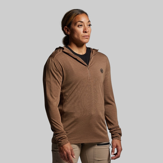 Person wearing a brown hoodie with a logo on a gray background