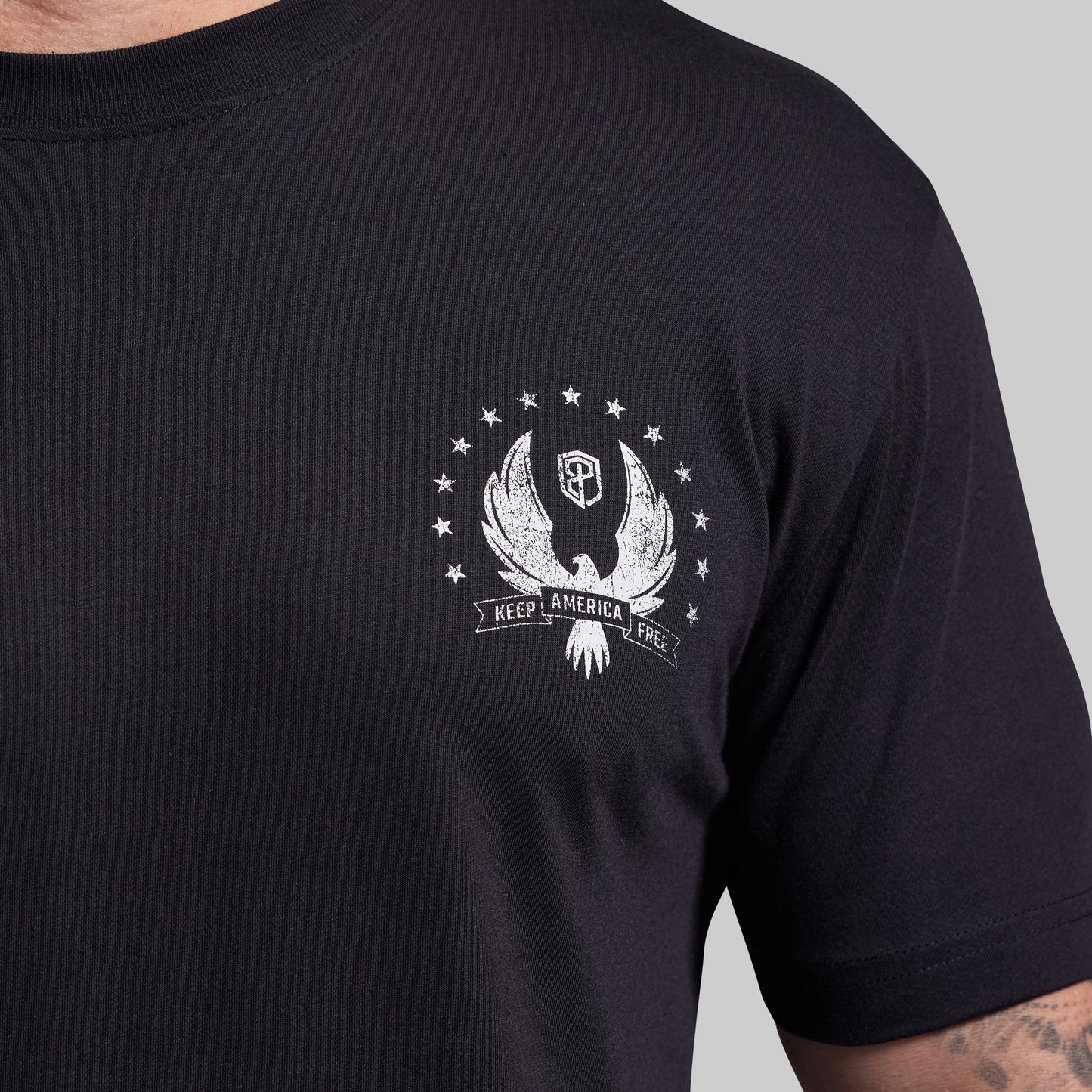 Black t-shirt with a white graphic design on a gray background