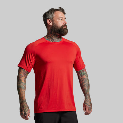 Man wearing a red t-shirt against a gray background