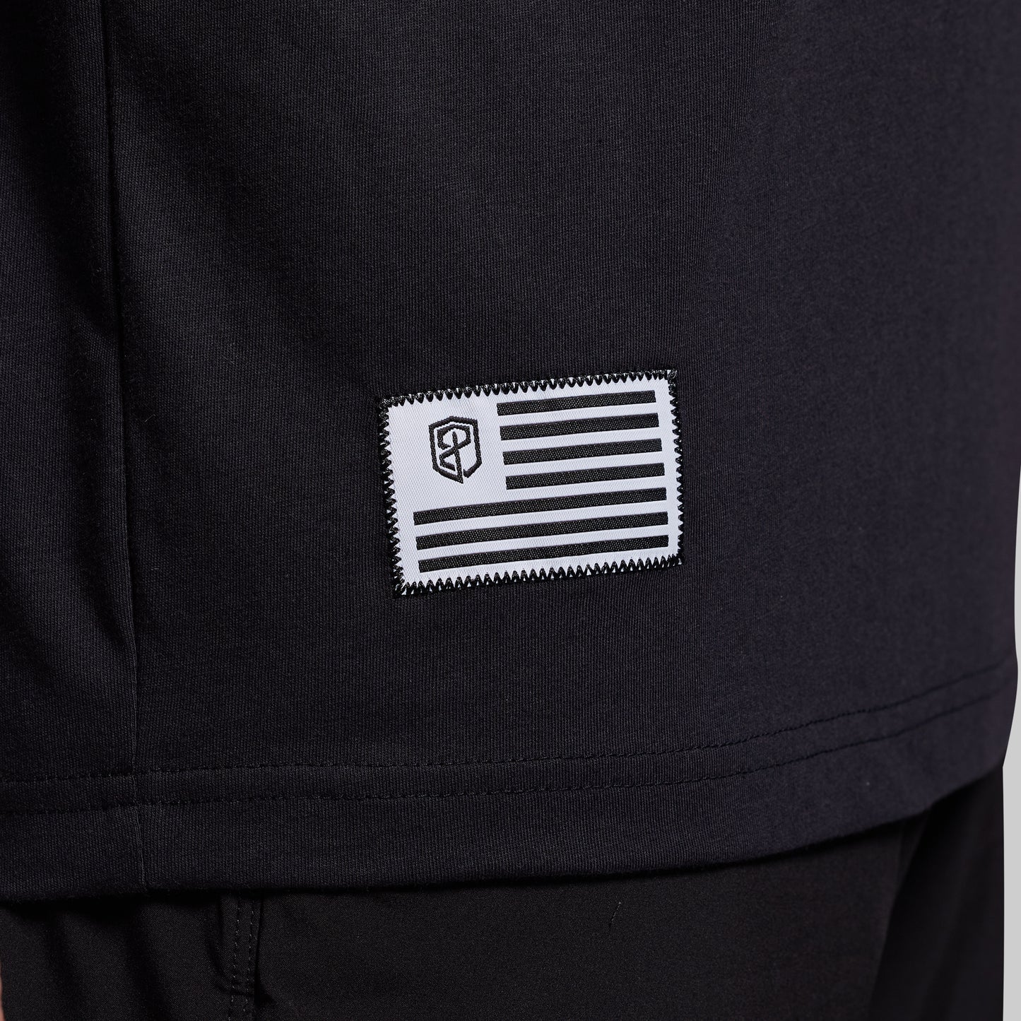 Black t-shirt with a flag patch on lower corner