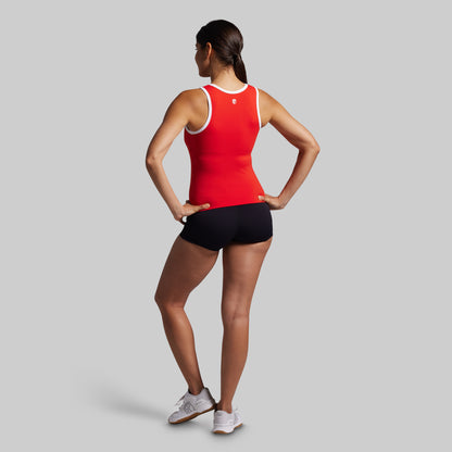 Person wearing a red tank top and black shorts on a gray background
