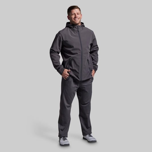 Man wearing a gray hoodie and pants on a light gray background