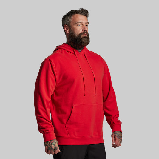 Man wearing a red hoodie against a gray background