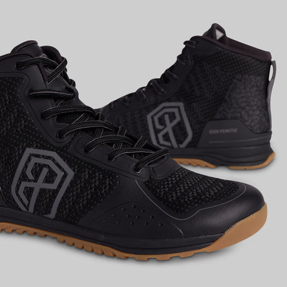 Black athletic shoes with brown soles on a gray background