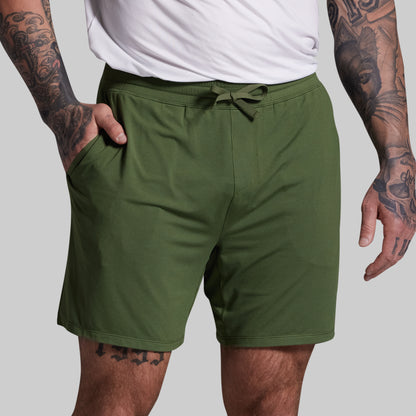 Person wearing green shorts on a plain background