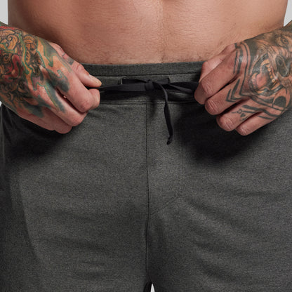 Person wearing dark gray shorts with a focus on the waistband.