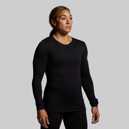 Person wearing a black long-sleeve shirt against a gray background