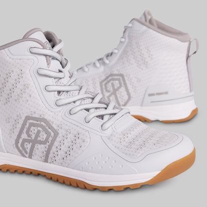 White athletic shoes with brown soles on a light gray background