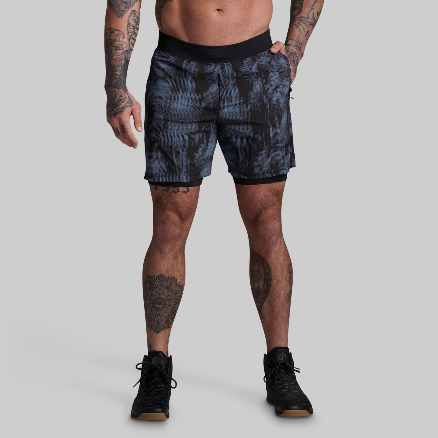 Person wearing patterned shorts on a plain background