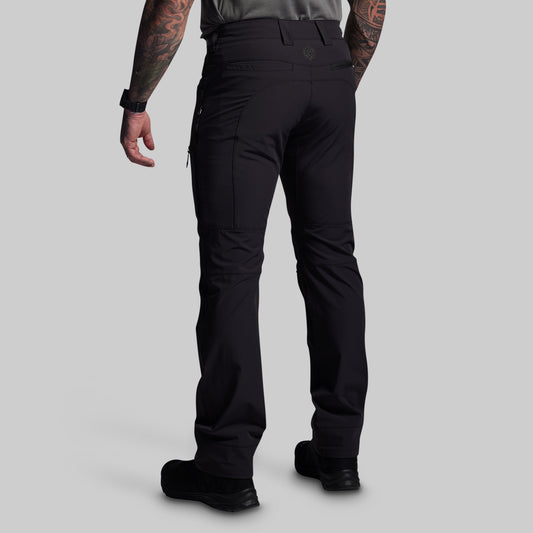 Person wearing black pants on a gray background