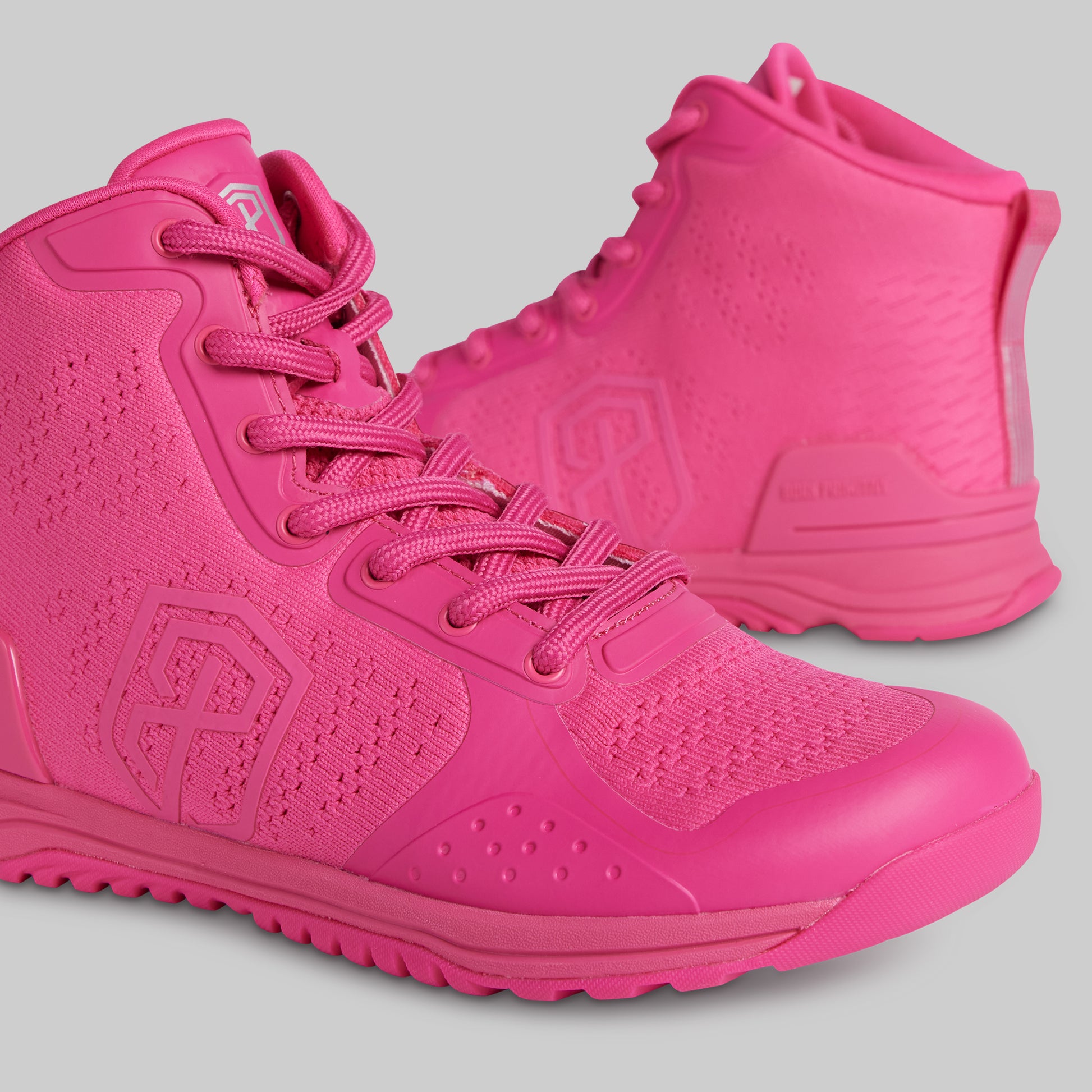 Pair of bright pink high-top sneakers on a gray background