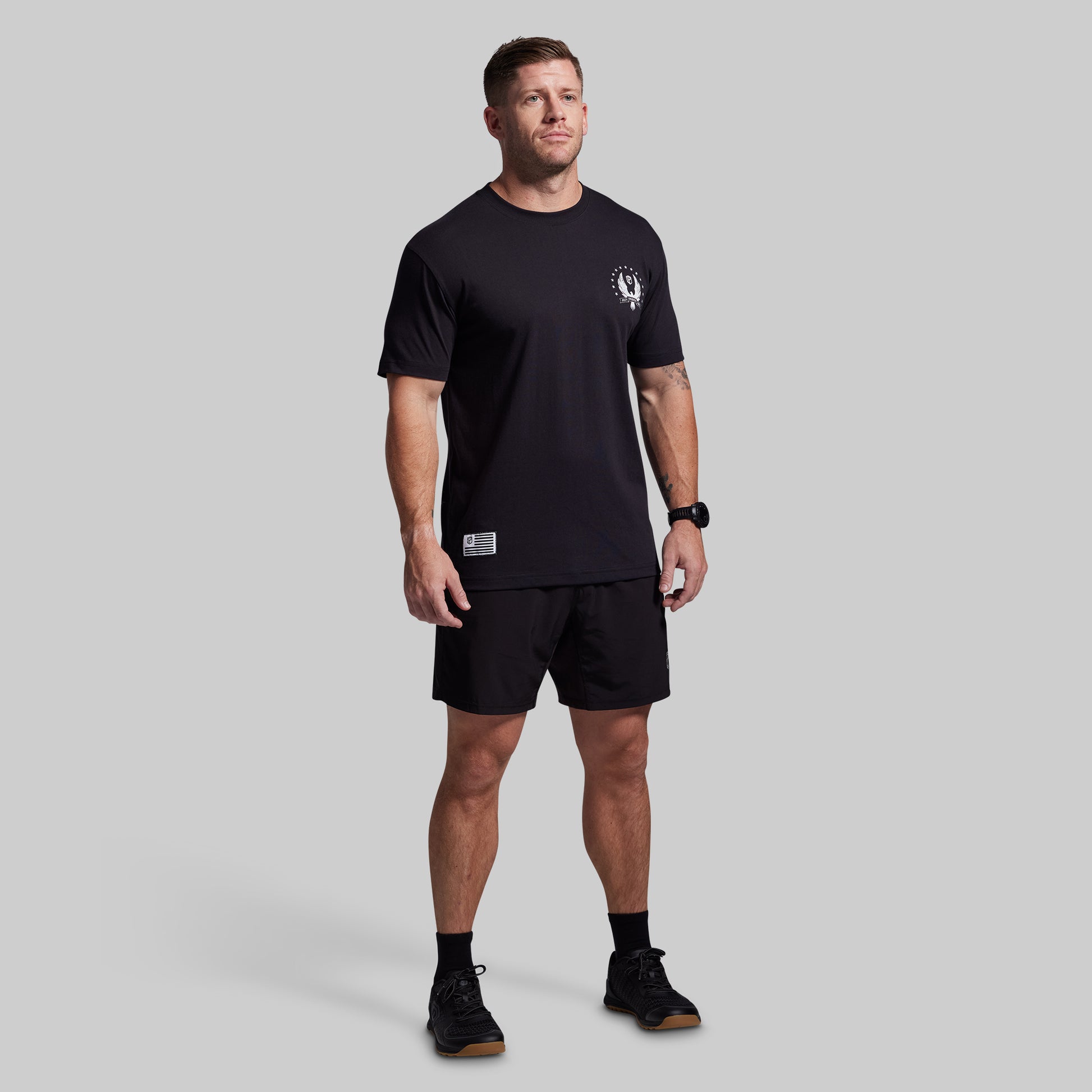 Man wearing a black t-shirt and shorts set on a gray background