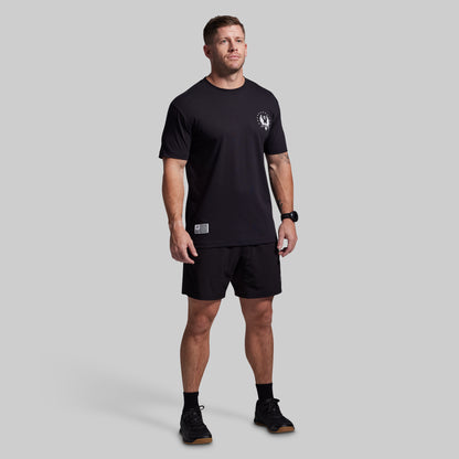 Man wearing a black t-shirt and shorts set on a gray background