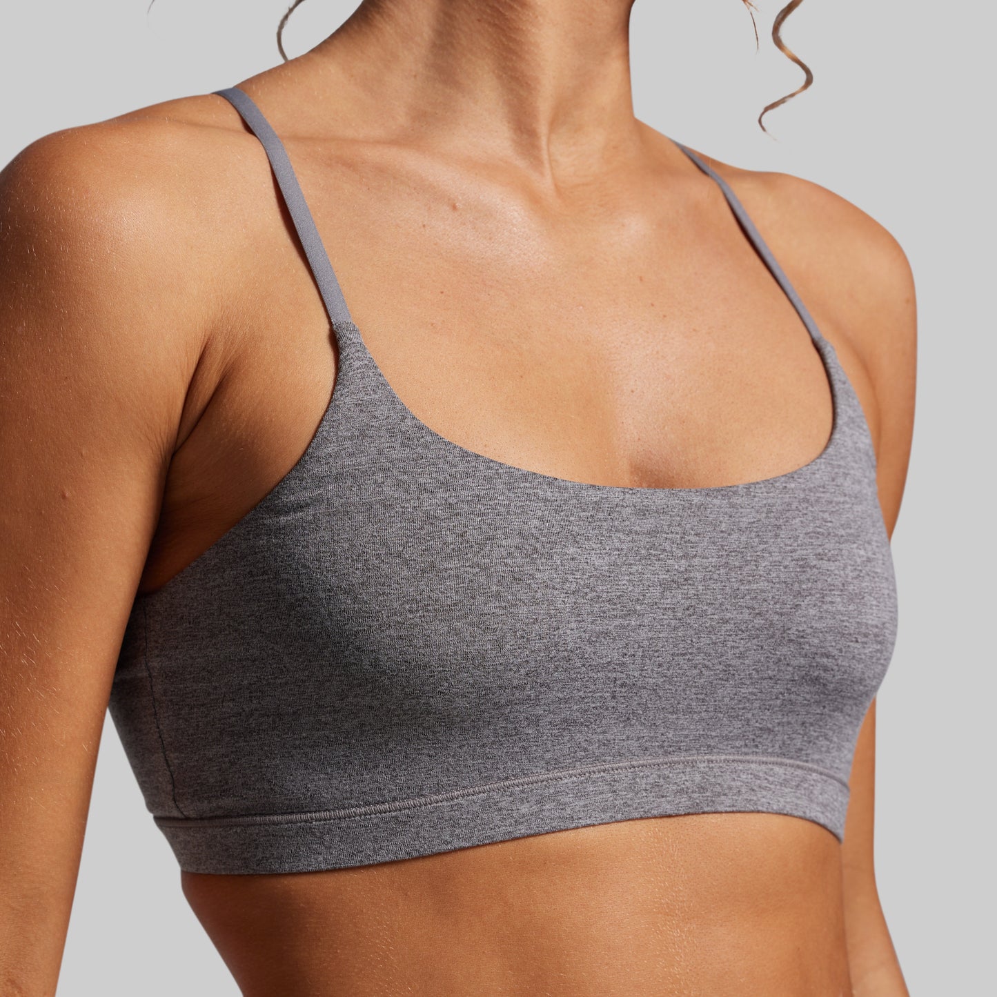 Gray sports bra worn by a person on a plain background