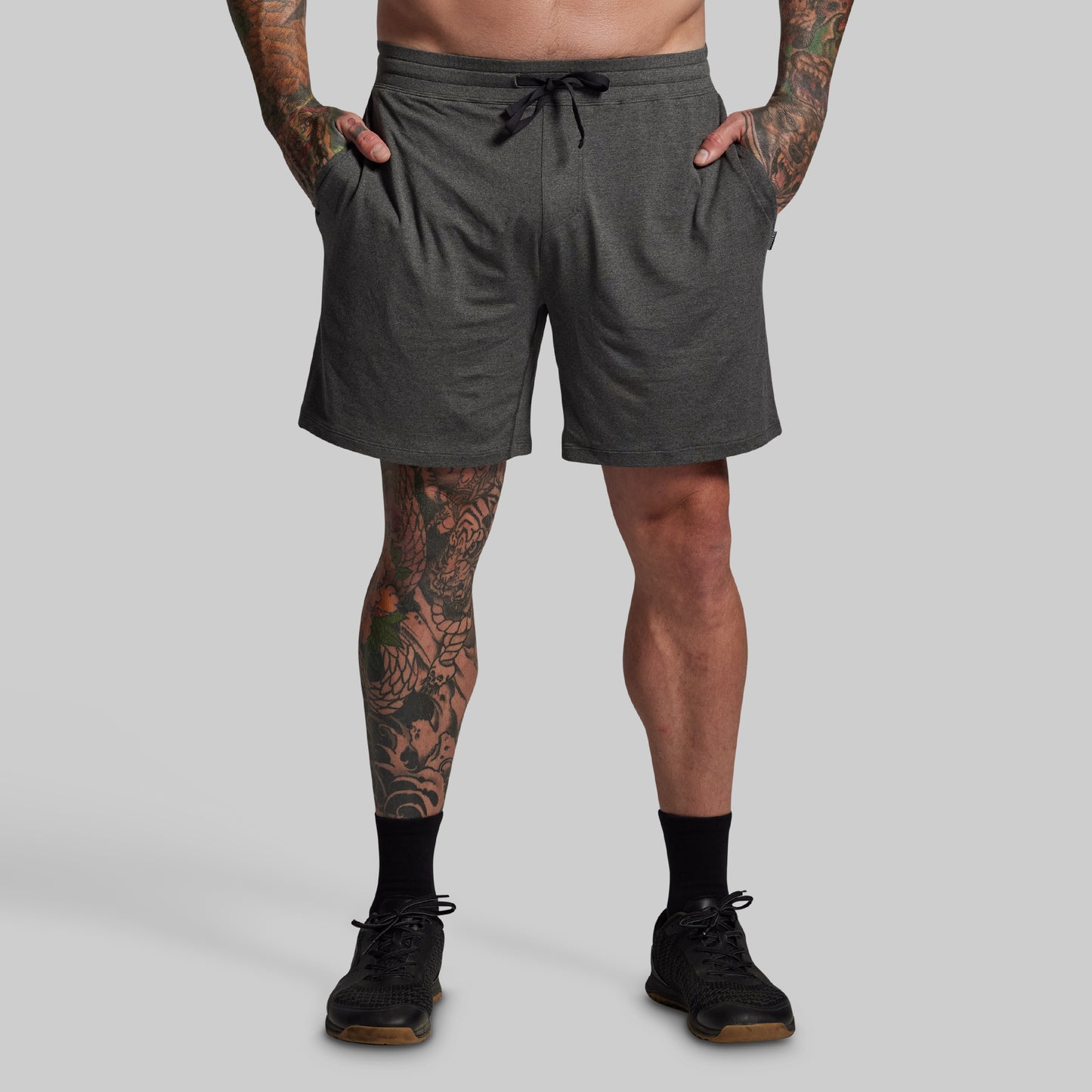 Person wearing gray shorts on a plain background