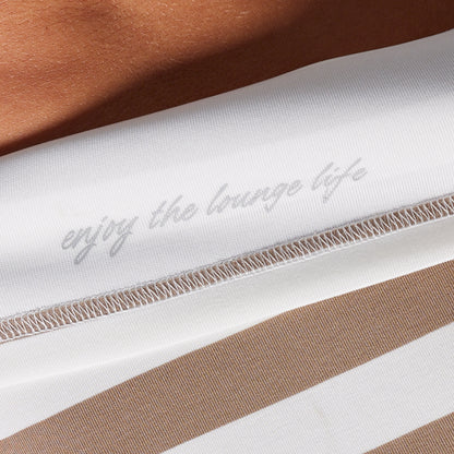 Striped fabric with 'enjoy the lounge life' embroidery on a brown background