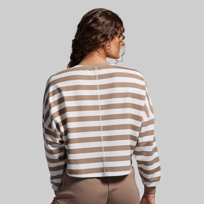 Woman wearing a brown and white striped shirt against a gray background