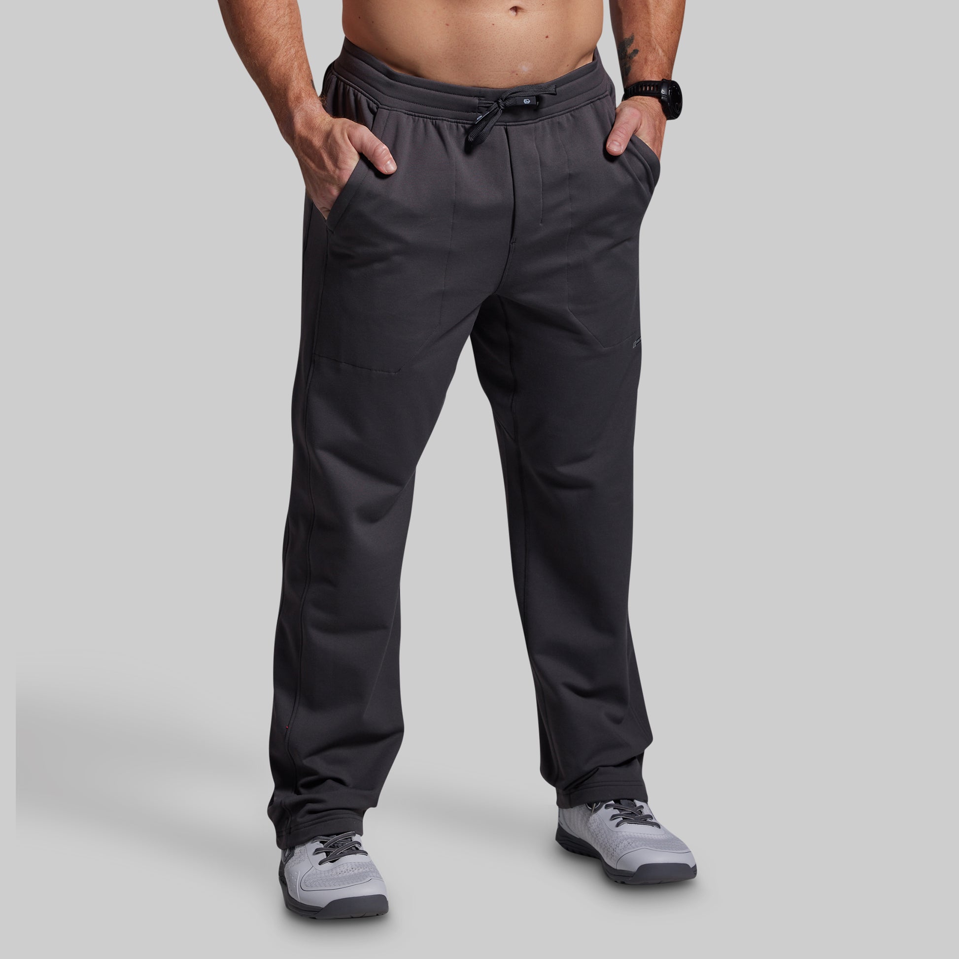 Person wearing dark gray pants on a light gray background