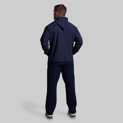Man wearing a navy tracksuit on a light gray background