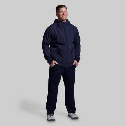 Man wearing a navy blue tracksuit on a light gray background