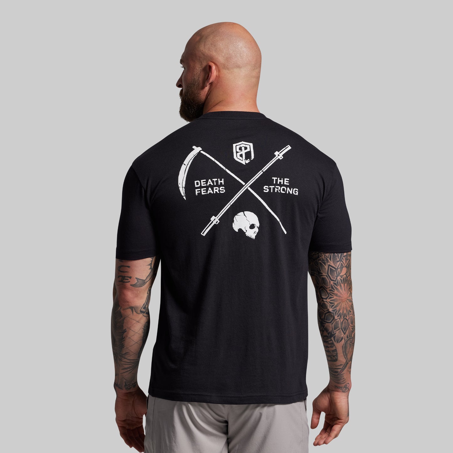 Man wearing a black t-shirt with a graphic design on the back, featuring text and symbols.