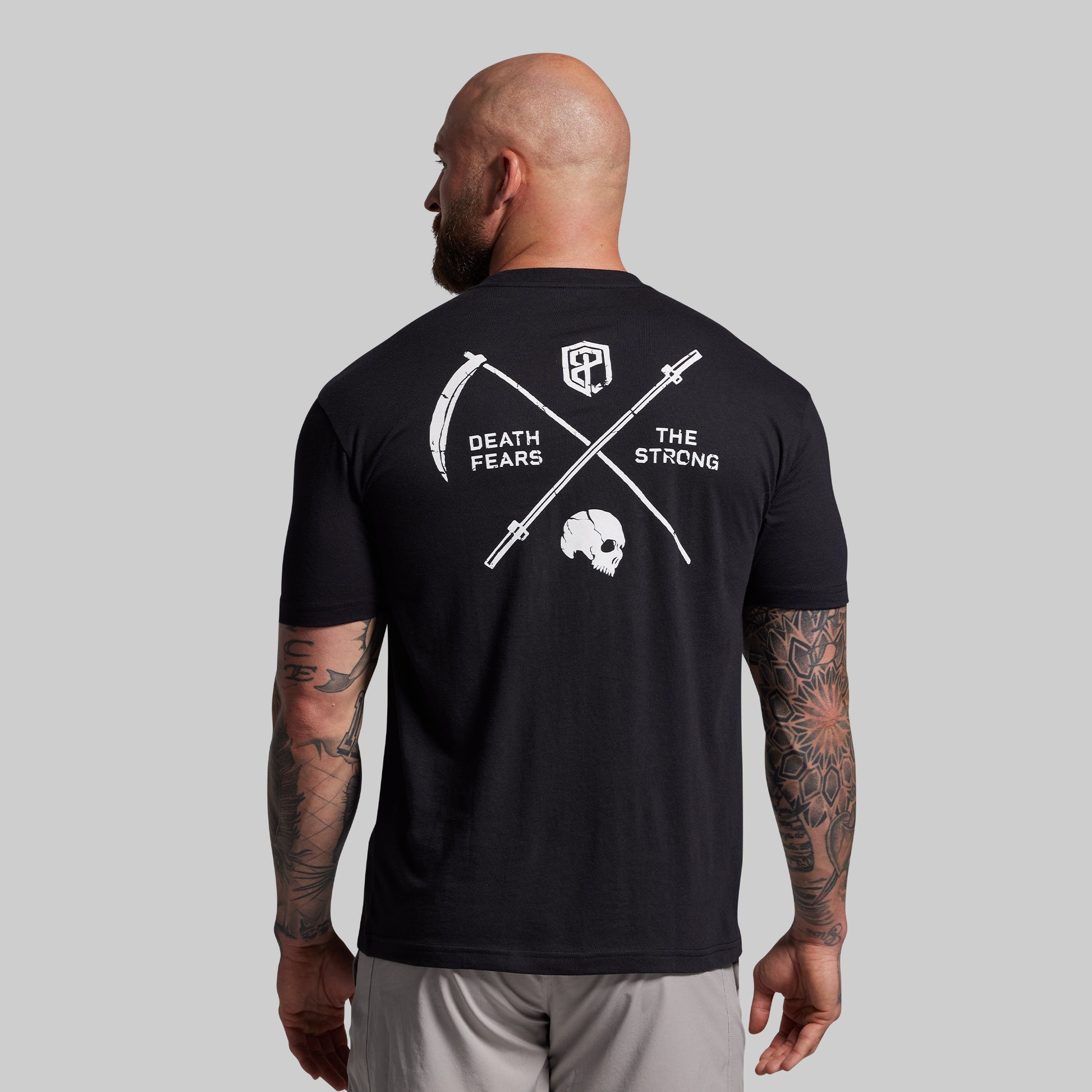 Man wearing a black t-shirt with a graphic design on the back, featuring text and symbols.
